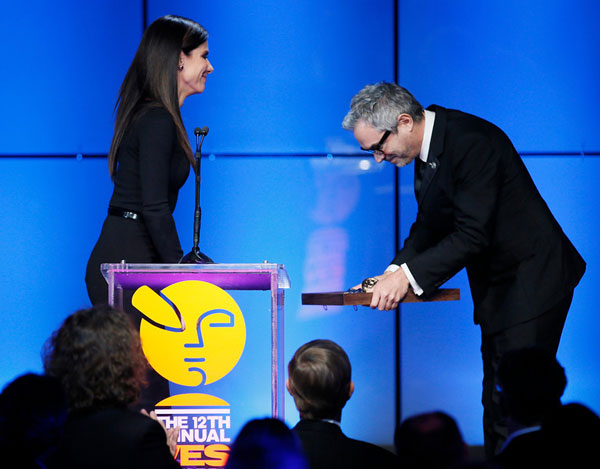 Actress Sandra Bullock, left, presents "Gravity" director Alfonso Cuaron with the Visionary Award during the 12th annual VES Awards. Photo by Danny Moloshok 